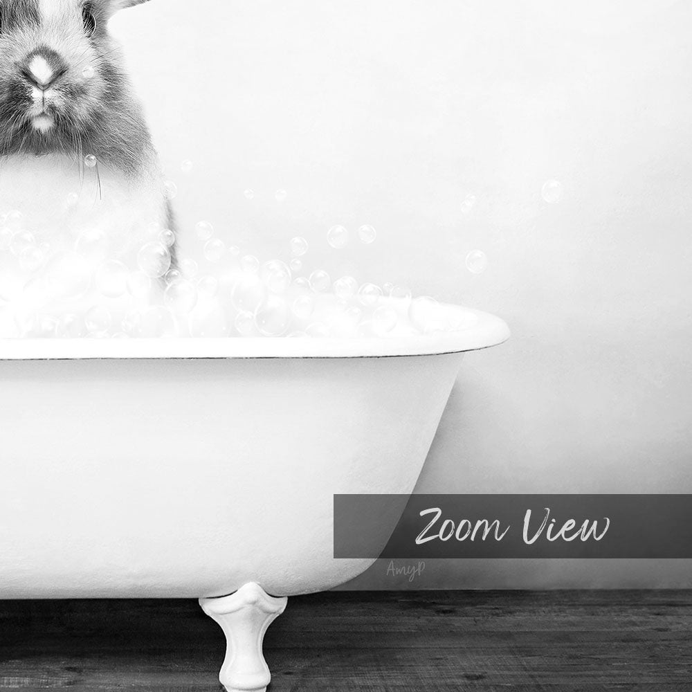 A rabbit sitting in a bathtub filled with bubbles, as captured in a black and white image.