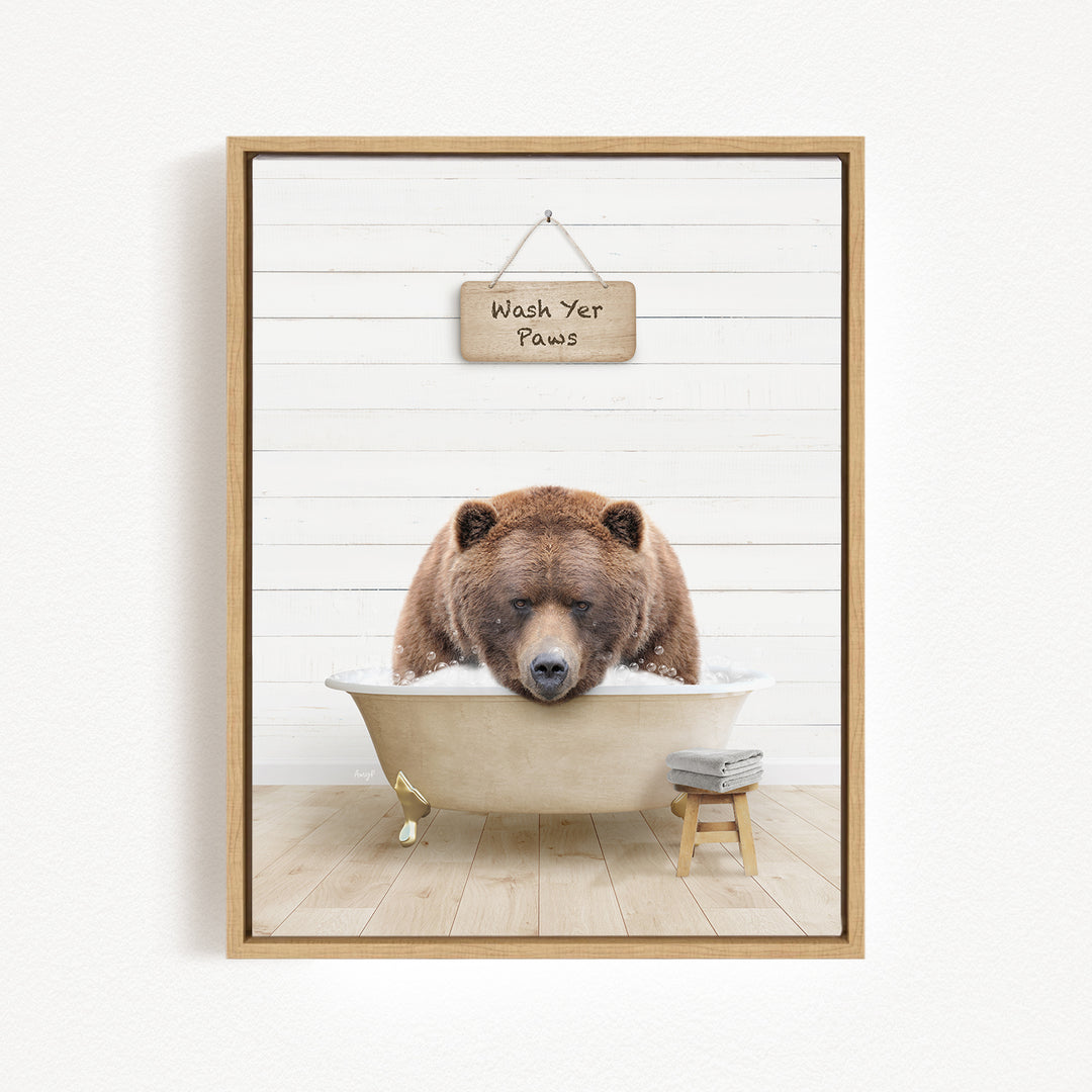 A brown bear is sitting in a bathtub, with a sign above it that says "Wash Your Paws".