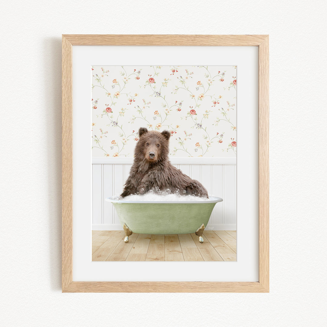 A brown bear sitting in a green bathtub filled with bubbles, with a floral wallpaper in the background.