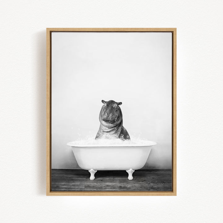 A black and white photograph of a hippopotamus sitting in a bathtub filled with water.