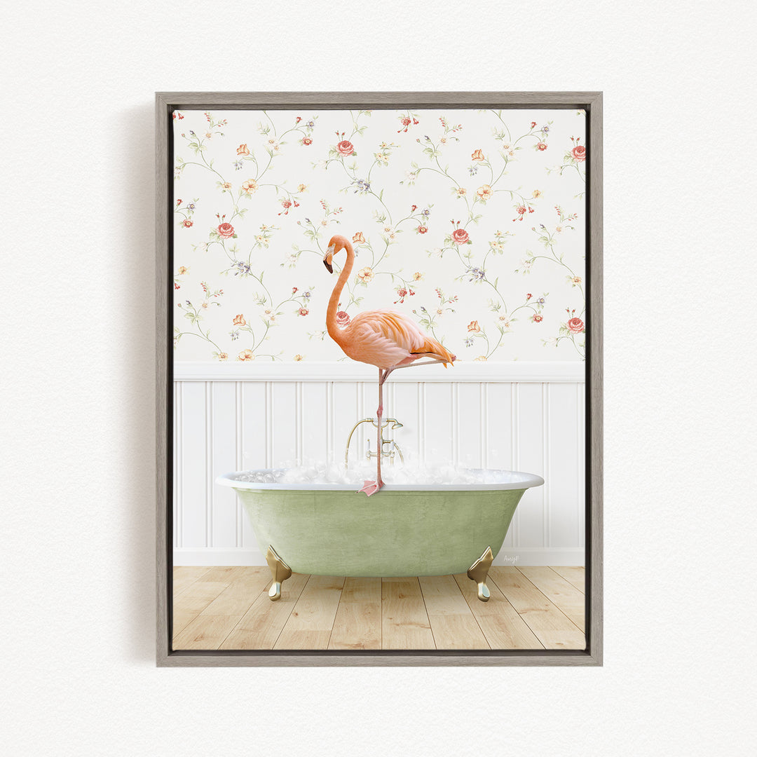 A pink flamingo stands on the edge of a green clawfoot bathtub, with a floral wallpaper in the background.