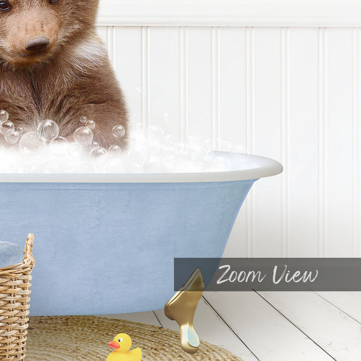 A small brown bear is sitting in a blue bathtub filled with bubbles, surrounded by a yellow rubber duck and a basket.