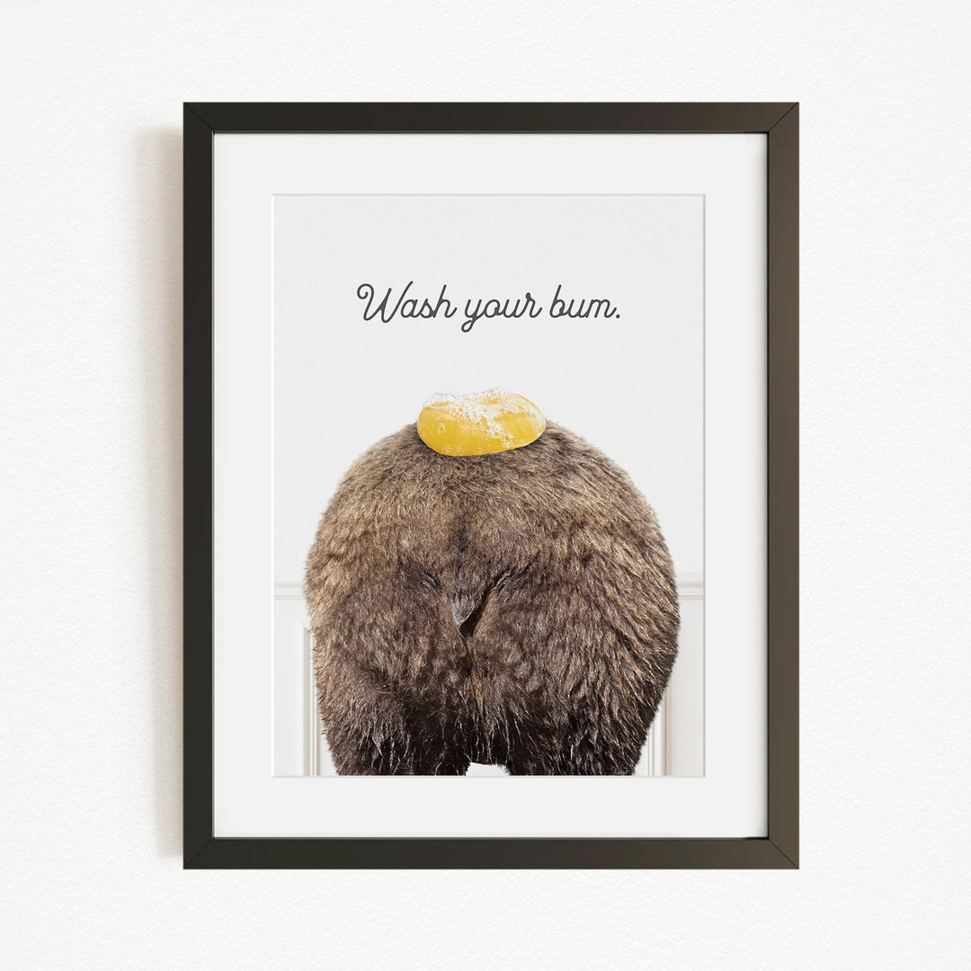 A framed image of a bear with a yellow object on its head, accompanied by the text "Wash your butt."