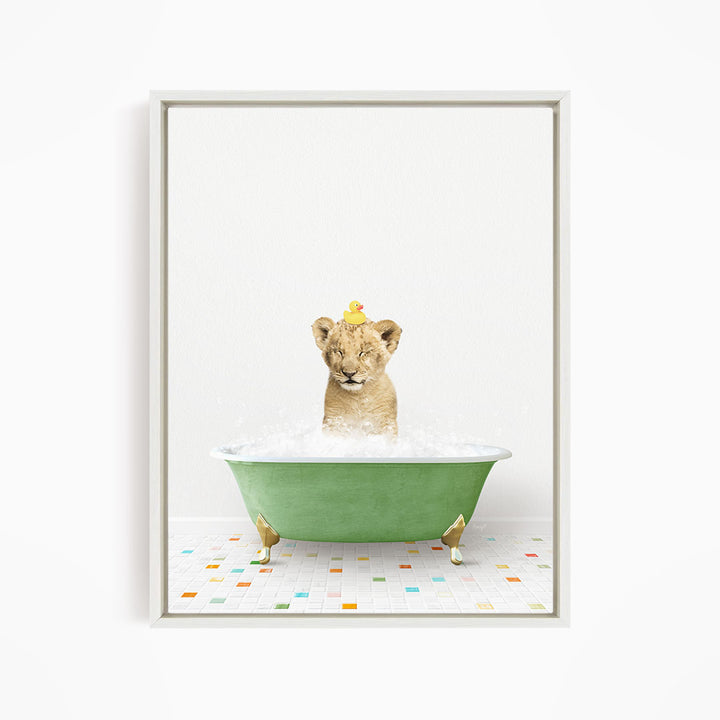 A young lion cub is sitting in a green bathtub filled with water, with a yellow rubber duck perched on its head.