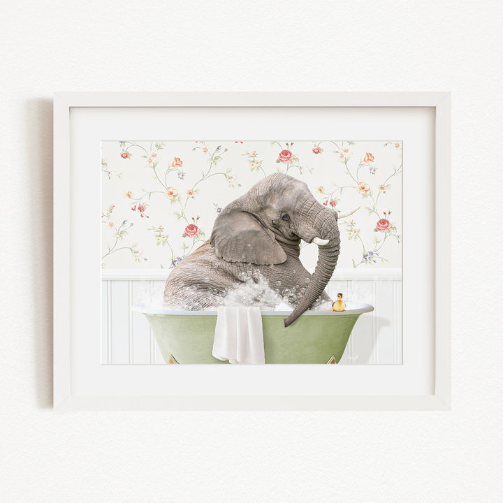 A gray elephant is sitting in a green bathtub filled with water, surrounded by a floral patterned wall.