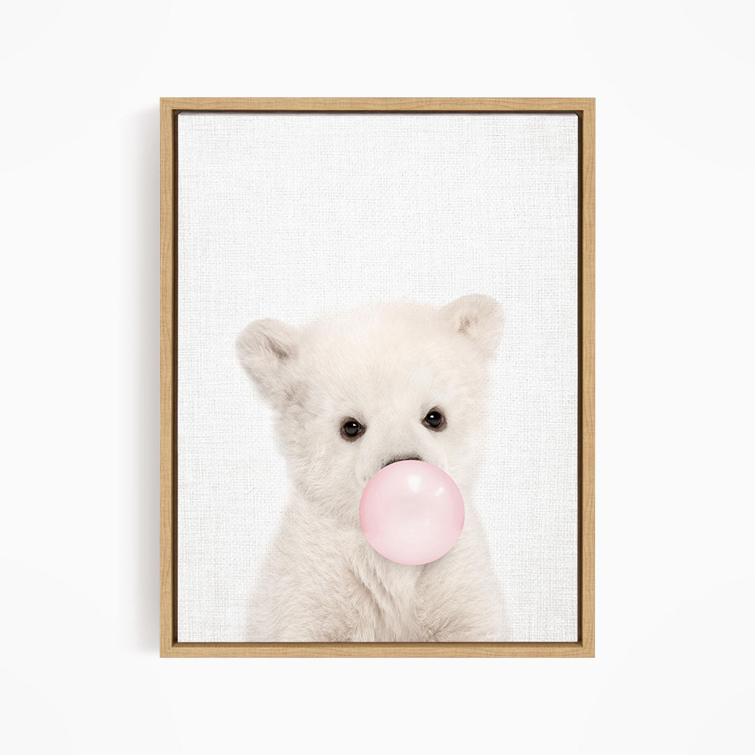 A cute white polar bear is blowing a bubble with a pink bubble gum bubble.