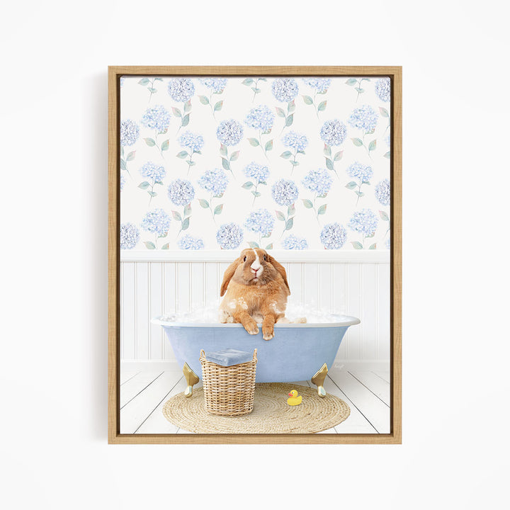 A brown rabbit sitting in a blue bathtub filled with water, surrounded by a wicker basket and rubber duckies.