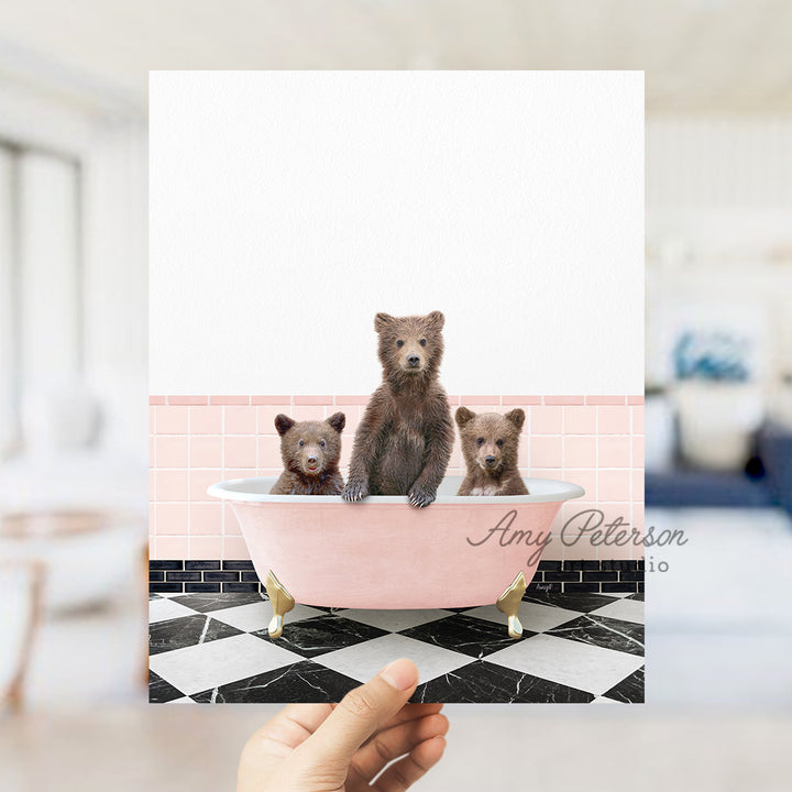 a person holding up a card with three bears in a bathtub