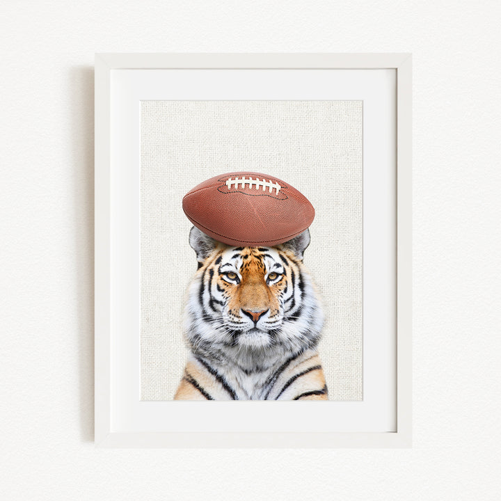 A tiger with a football on its head is the main subject of the image.