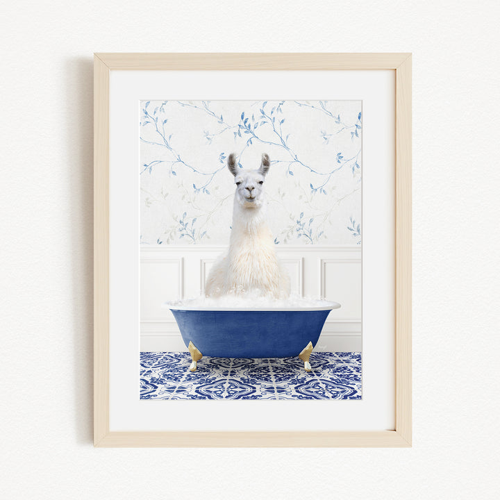A white llama sitting in a blue bathtub, surrounded by a blue and white patterned tile floor.
