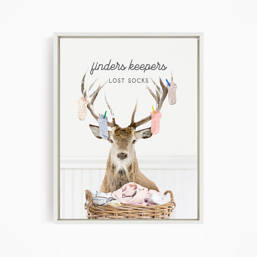 A deer with antlers holding socks in its mouth, standing in a basket filled with clothes.