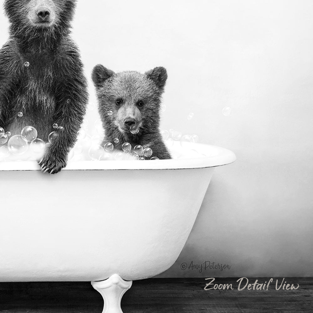 A black and white image showing two bears, one larger and one smaller, sitting in a bathtub filled with bubbles.