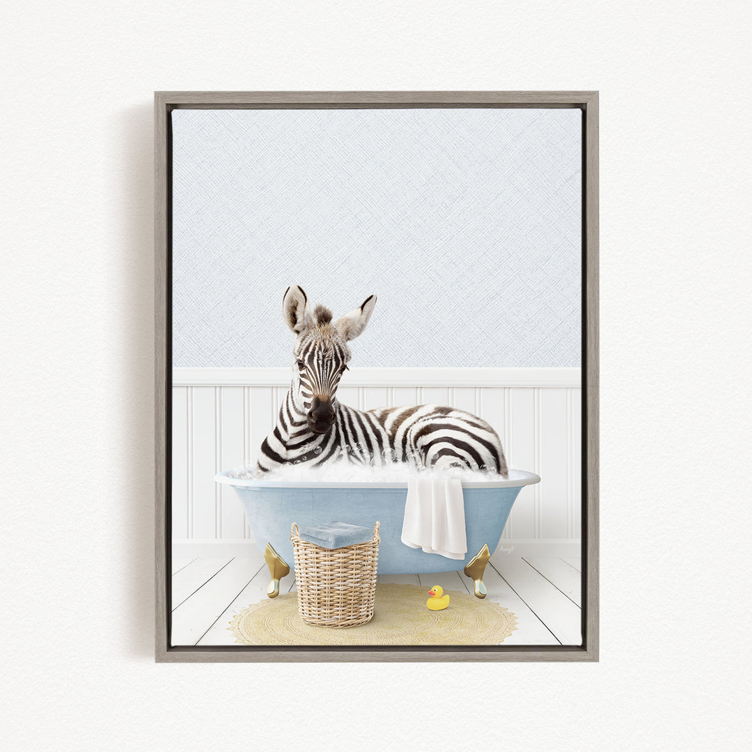 A zebra is sitting in a blue bathtub filled with water, surrounded by a yellow rubber duck and a wicker basket.
