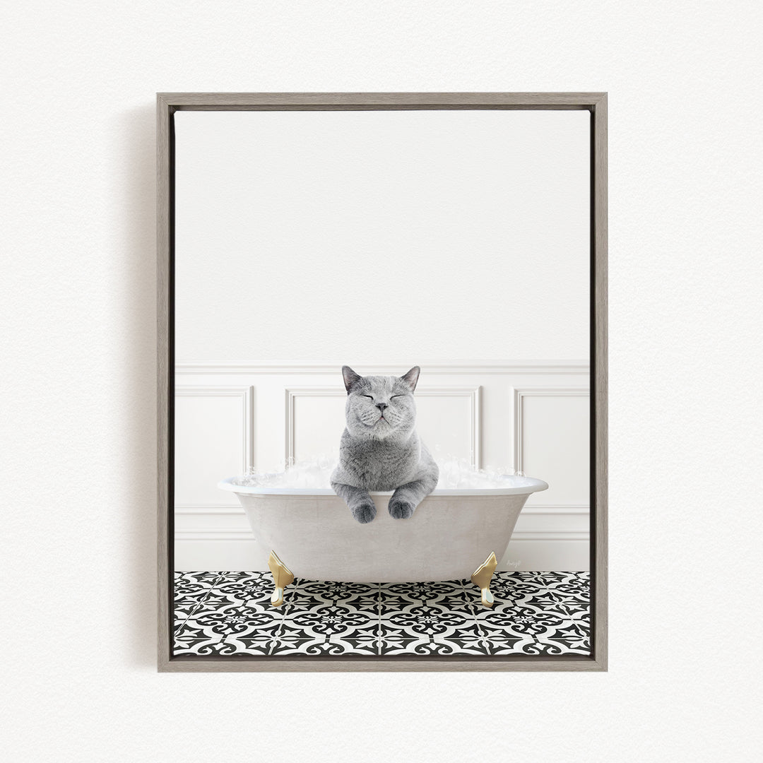 A gray cat sitting in a white bathtub filled with bubbles, with a black and white patterned floor in the background.