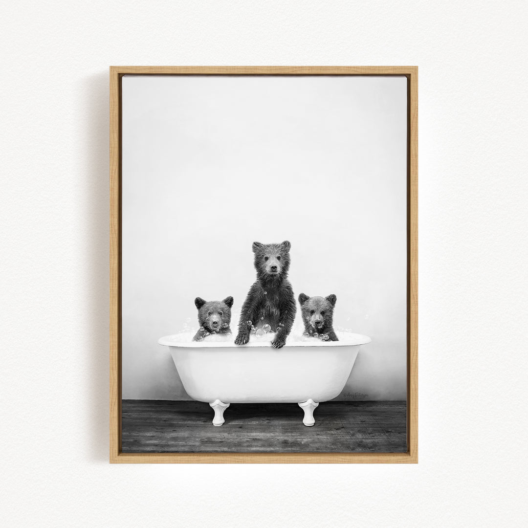 A black and white photograph of three bears sitting in a bathtub, with one bear sitting in the center and the other two bears sitting on either side.
