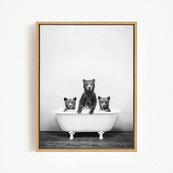 A black and white photograph of three bears sitting in a bathtub, with one bear sitting in the center and the other two bears sitting on either side.