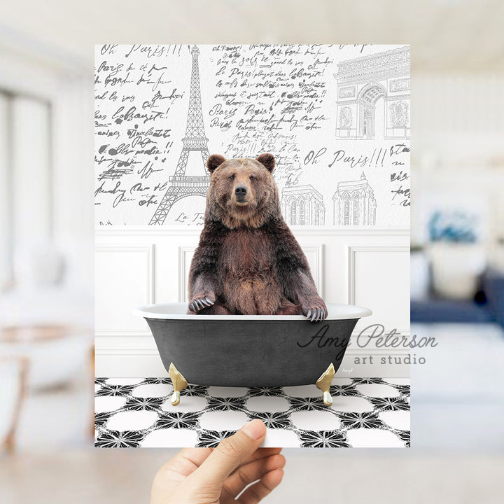 a person holding up a card with a bear in a bathtub