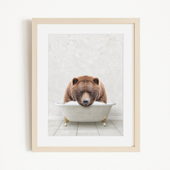 A brown bear is sitting in a white bathtub, appearing to be enjoying a relaxing bath.