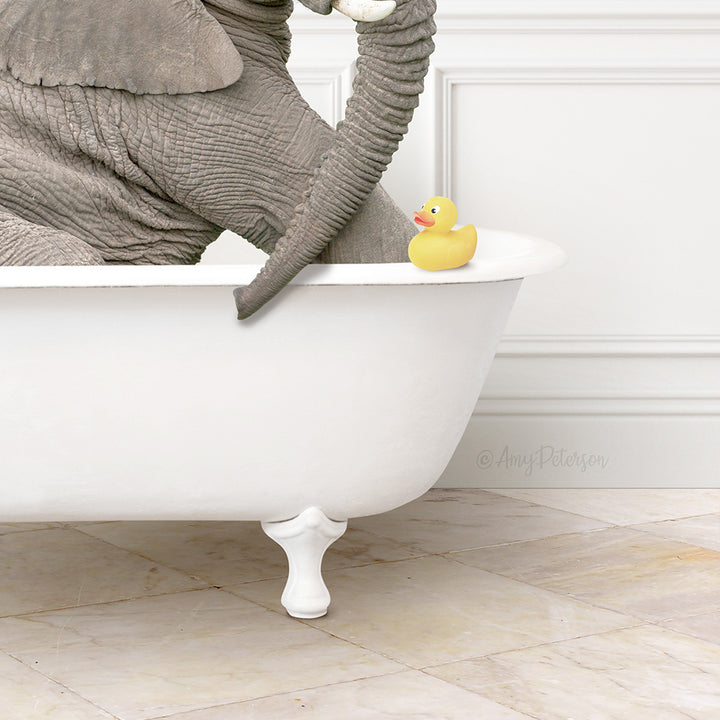 A gray elephant is sitting in a white bathtub, with a yellow rubber duck resting on the edge of the tub.