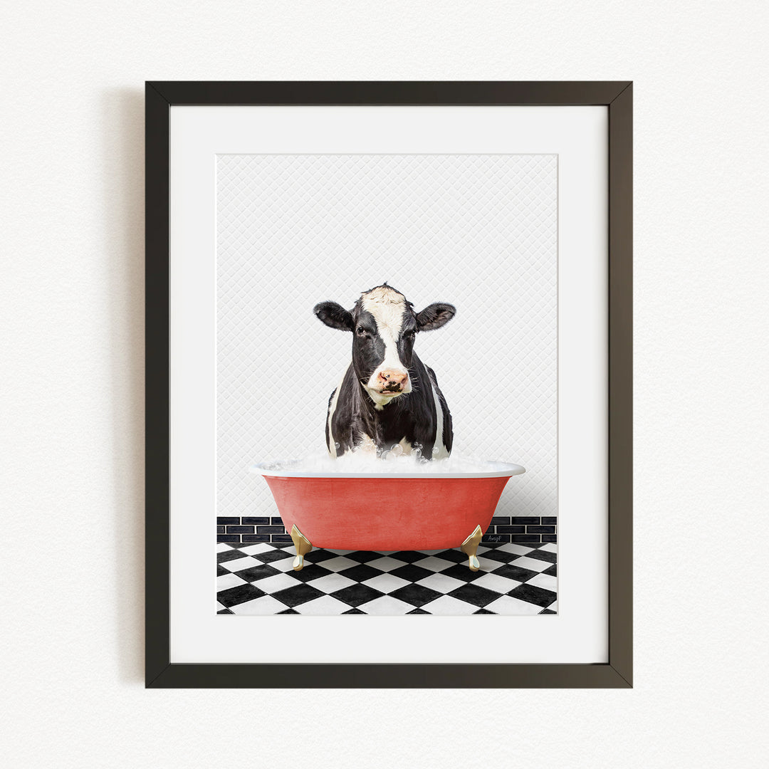 A black and white cow is sitting in a red bathtub filled with water, creating a whimsical and humorous scene.