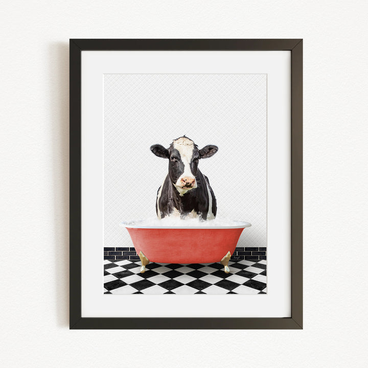 A black and white cow is sitting in a red bathtub filled with water, creating a whimsical and humorous scene.