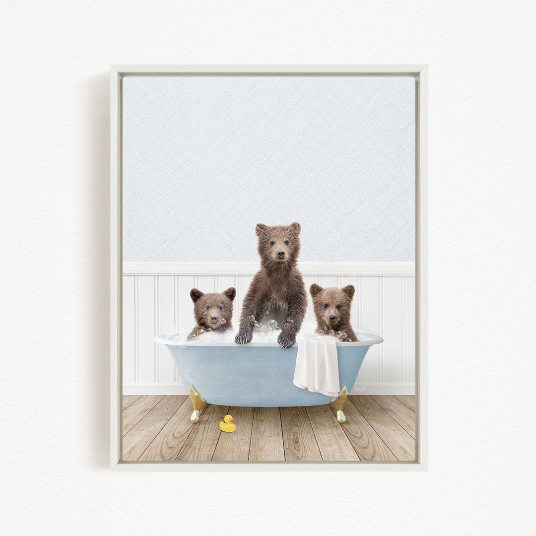 A framed image depicting three adorable brown bears sitting in a blue bathtub, with a towel and rubber duck nearby.