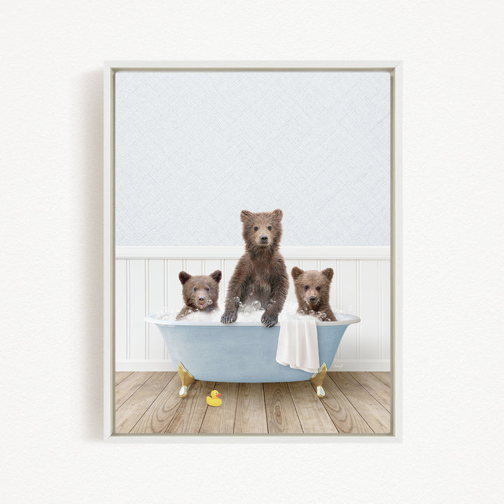 A framed image depicting three adorable brown bears sitting in a blue bathtub, with a towel and rubber duck nearby.