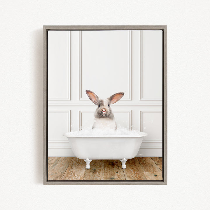 A white rabbit sitting in a white bathtub filled with bubbles, looking directly at the camera.