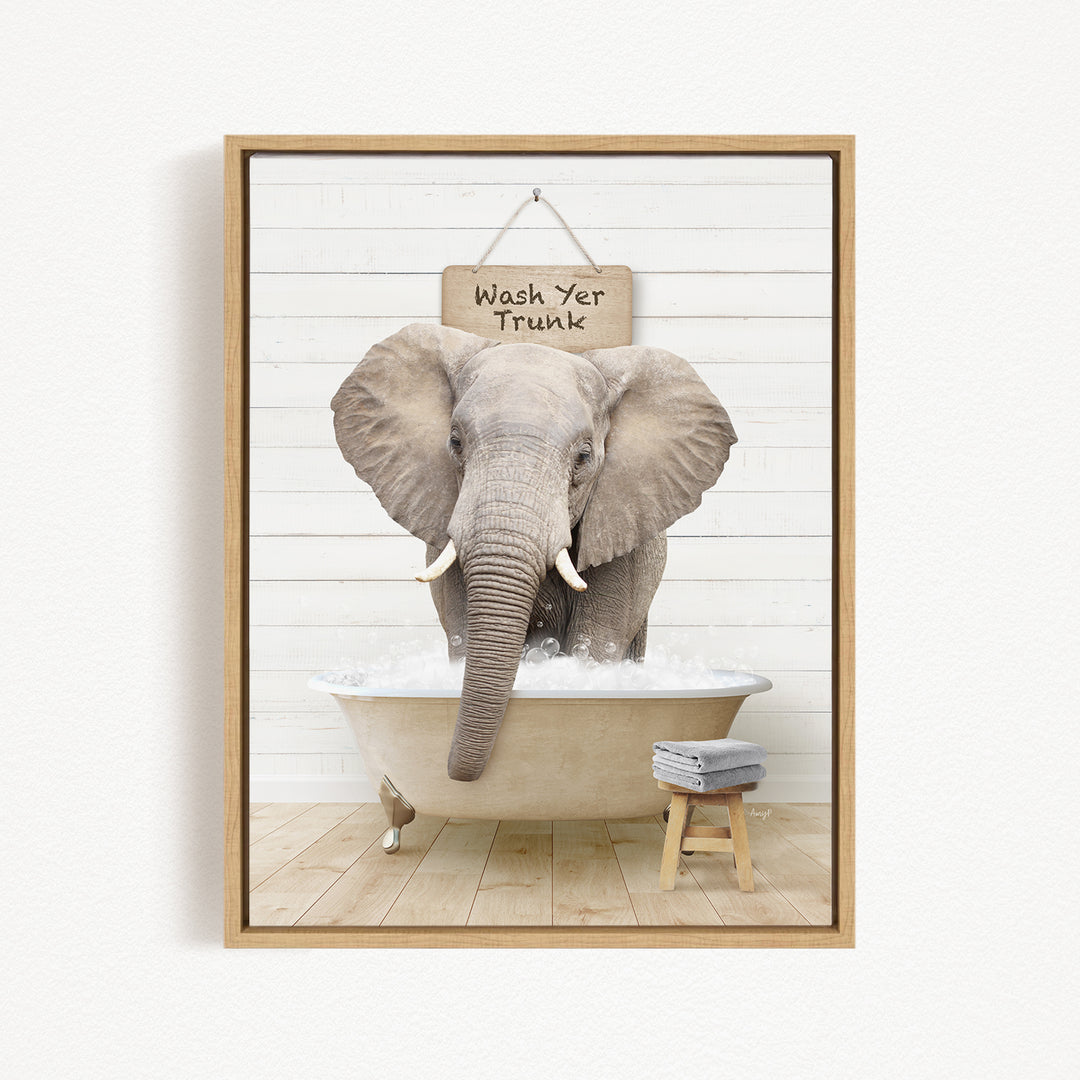 A gray elephant standing in a bathtub, with a sign above it that says "Wash Yer Trunk".