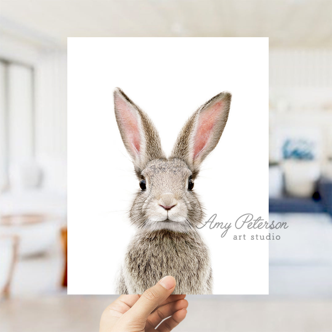 a person holding up a card with a picture of a rabbit