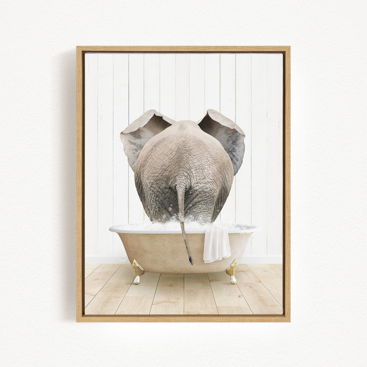 A gray elephant is sitting in a white bathtub filled with water, with its trunk submerged in the water.