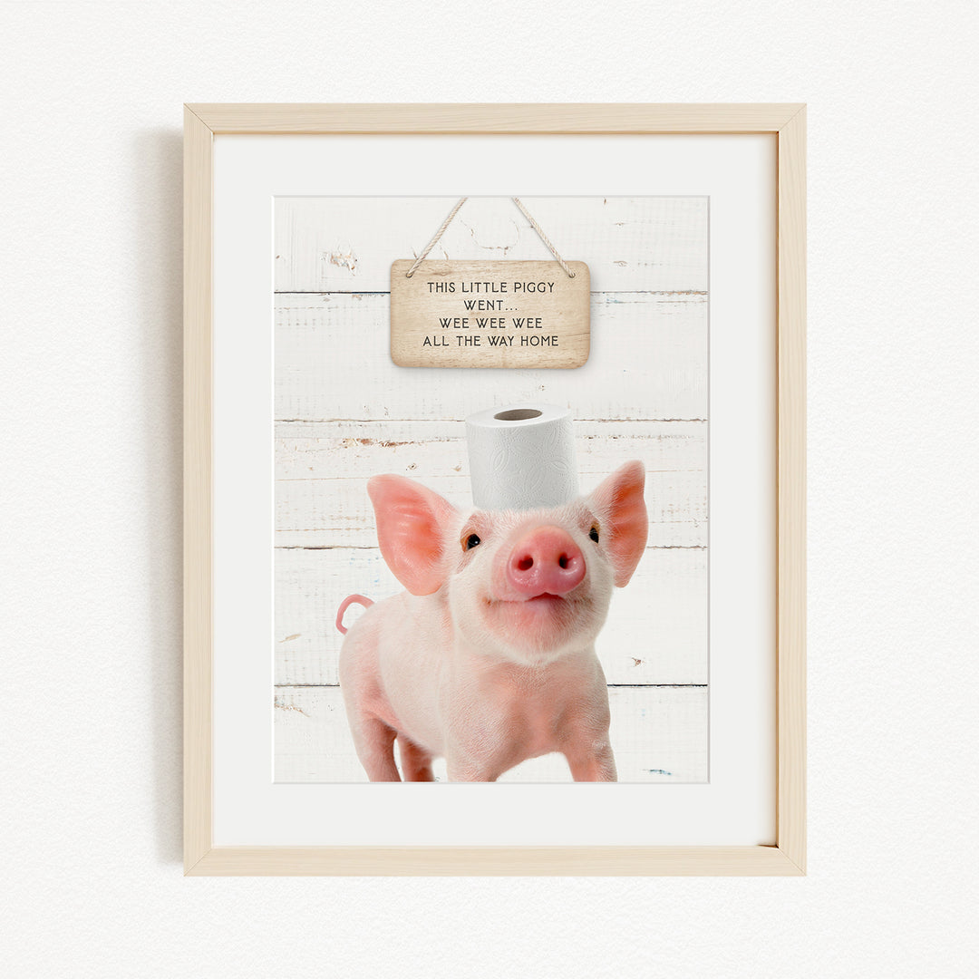 A framed image of a pig with a sign above it that reads "This little piggy went weee weee all the way home".