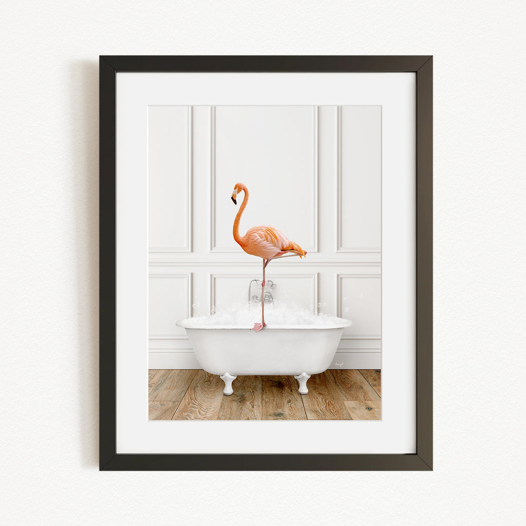 A framed image of a flamingo standing on the edge of a white bathtub filled with water.