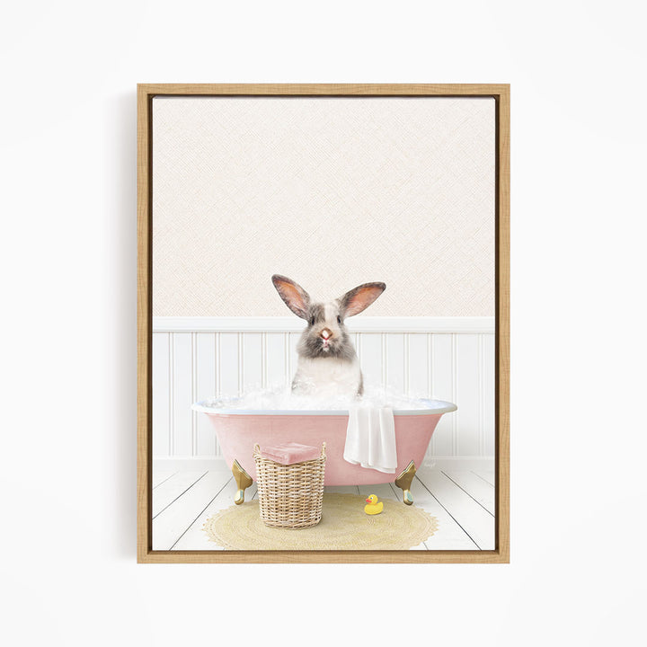 A fluffy white rabbit sits in a pink bathtub filled with bubbles, surrounded by a yellow rubber duck and a basket.