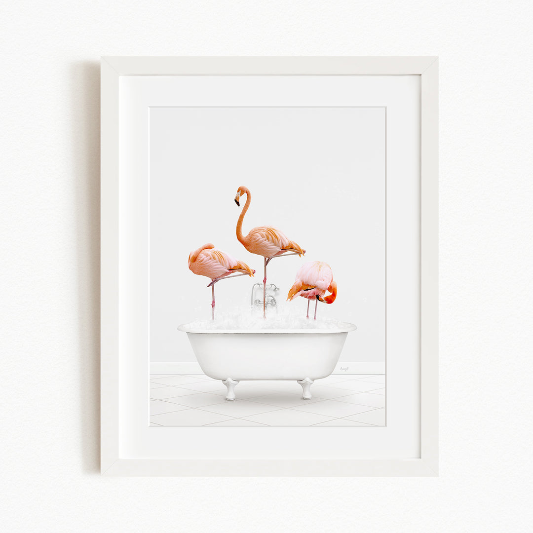 A framed image depicting three flamingos standing in a white bathtub filled with water.