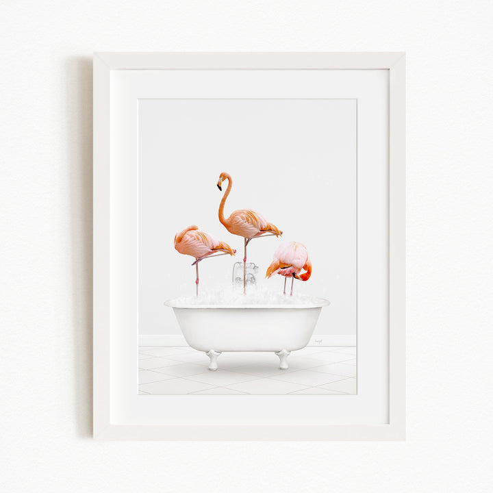 A framed image depicting three flamingos standing in a white bathtub filled with water.