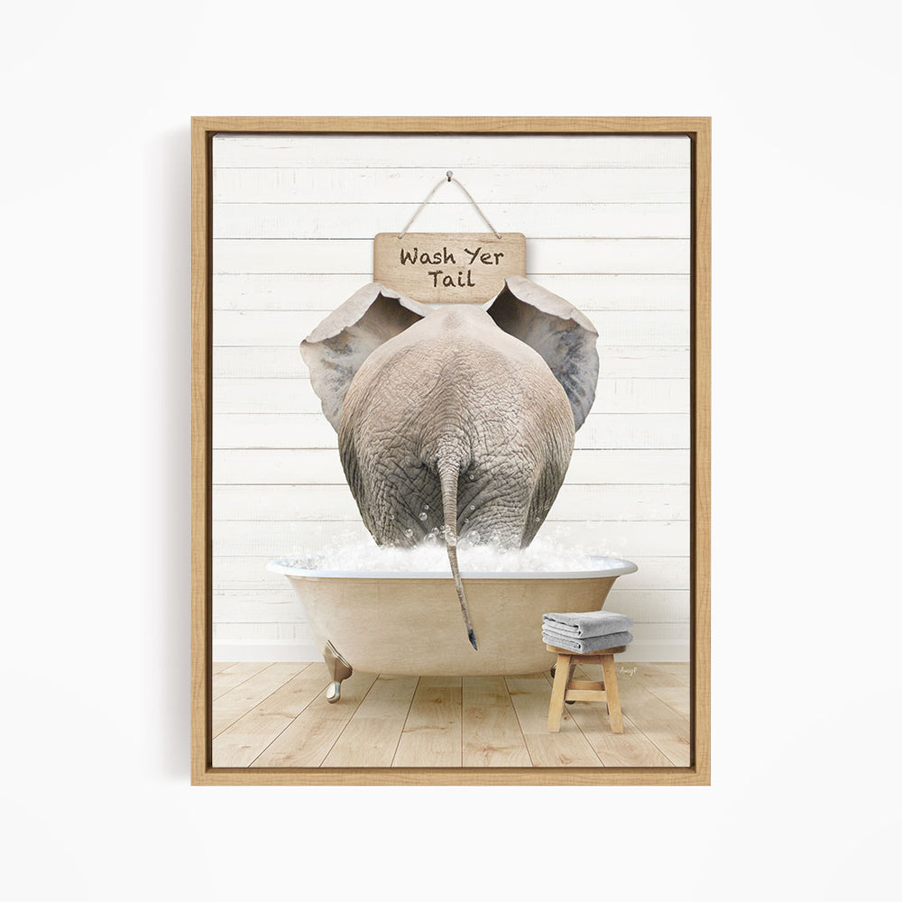 A framed image depicting an elephant standing in a bathtub, with a sign above it that says "Wash Yer Tail".