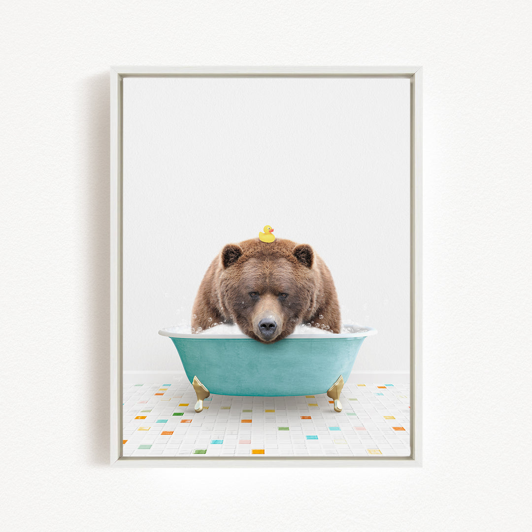 A brown bear is sitting in a blue bathtub, surrounded by colorful tiles on the floor.