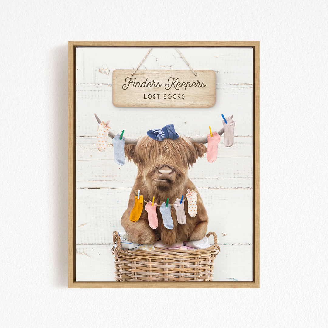 A brown cow with long hair sits in a wicker basket, wearing a blue bow and surrounded by colorful socks hanging from clotheslines.