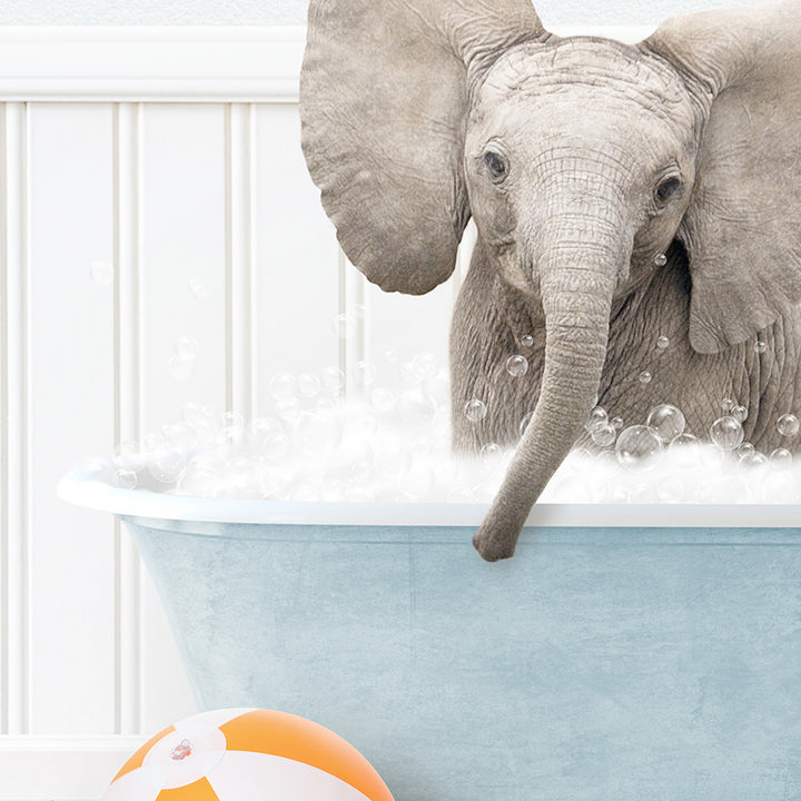 an elephant in a bathtub with bubbles and a beach ball