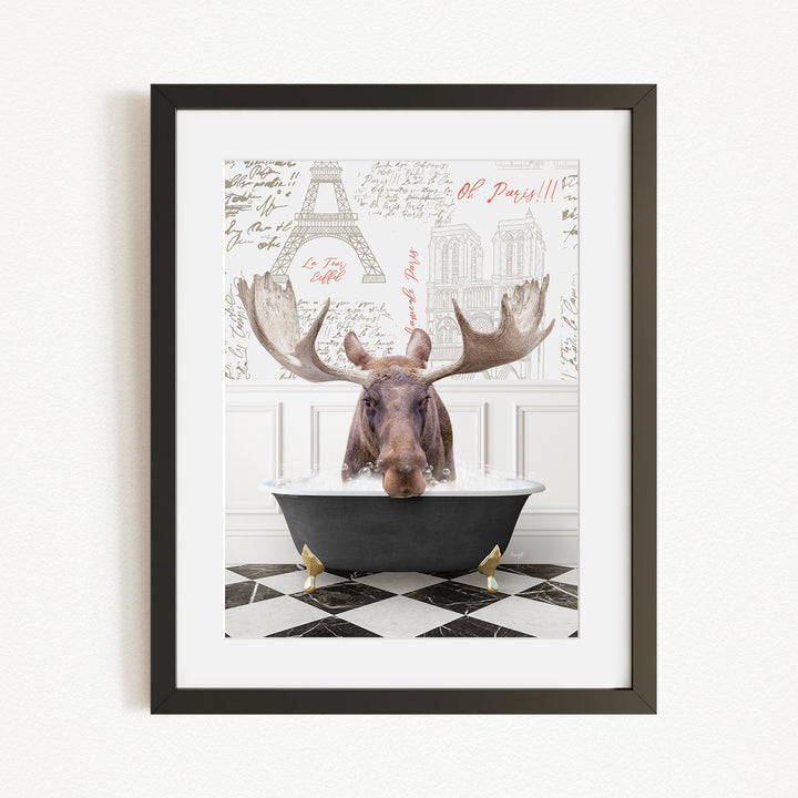 A moose is sitting in a bathtub, with a framed picture of the Eiffel Tower in the background.
