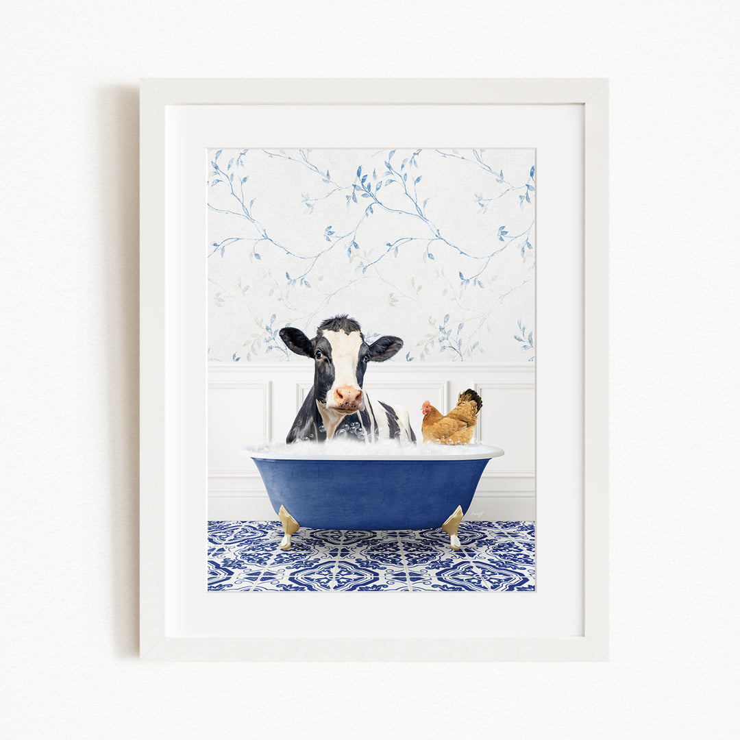 A black and white cow is sitting in a blue bathtub, surrounded by a chicken and a rooster, in a white-framed picture.