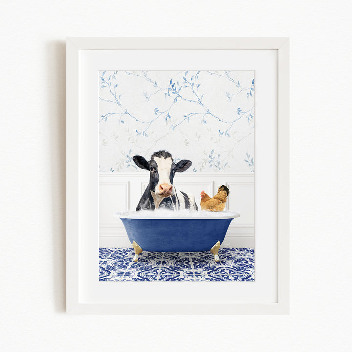 A black and white cow is sitting in a blue bathtub, surrounded by a chicken and a rooster, in a white-framed picture.