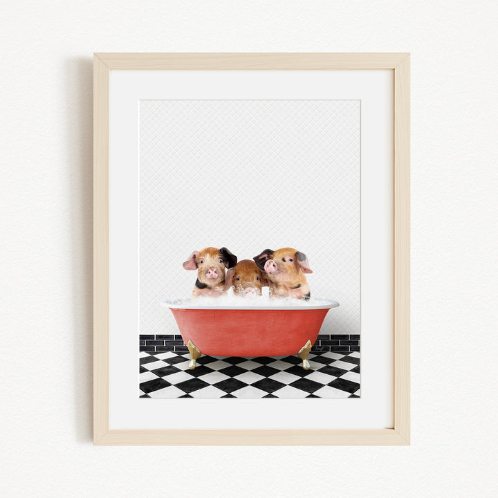 Three adorable pigs sitting in a red bathtub on a black and white checkered floor.