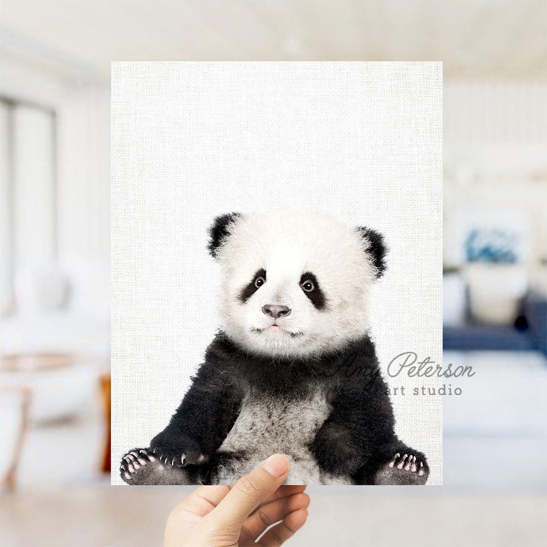 a hand holding a picture of a panda bear