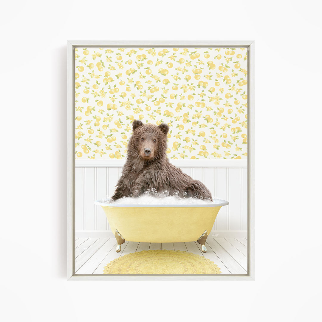 A brown bear sitting in a yellow bathtub filled with bubbles, surrounded by a yellow floral wallpaper.