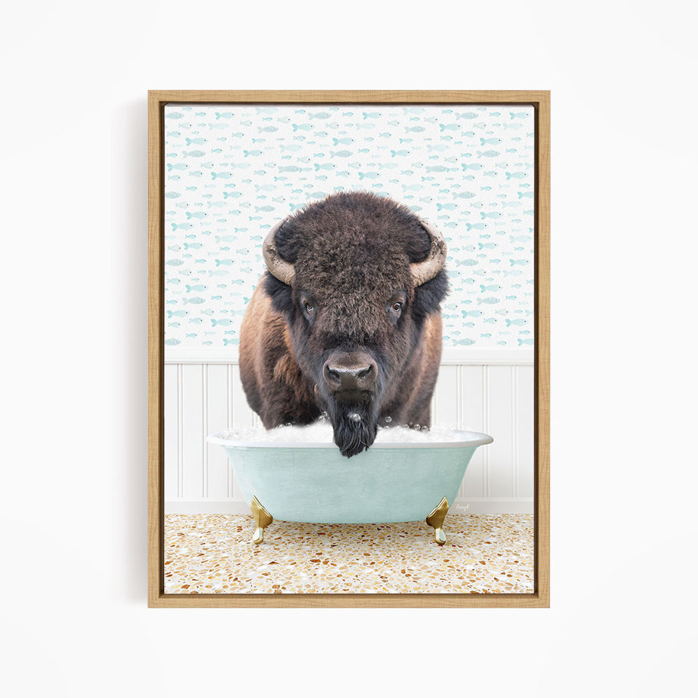 A buffalo with a black mane and horns is sitting in a light blue bathtub, with a patterned wall behind it.