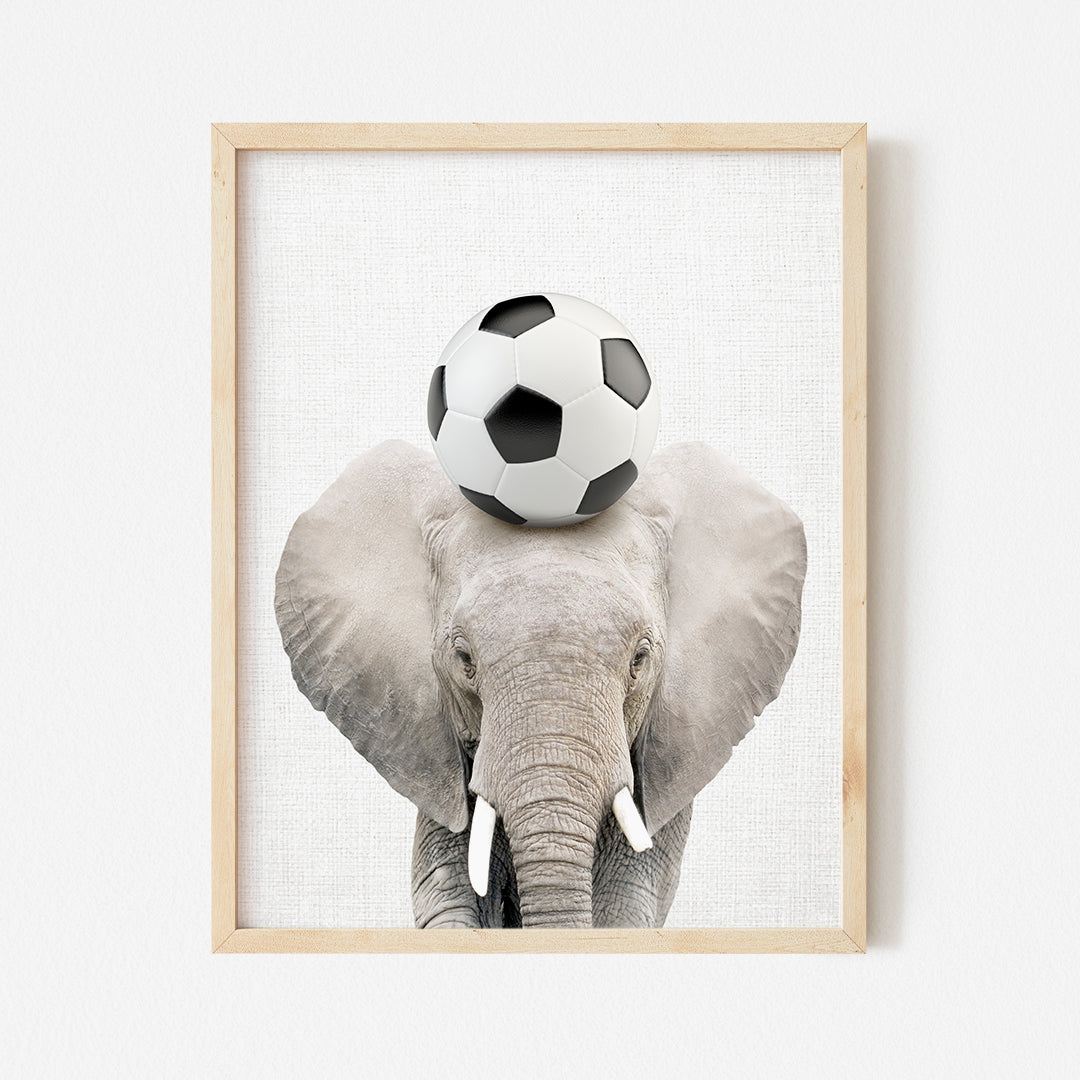 an elephant with a soccer ball on its head