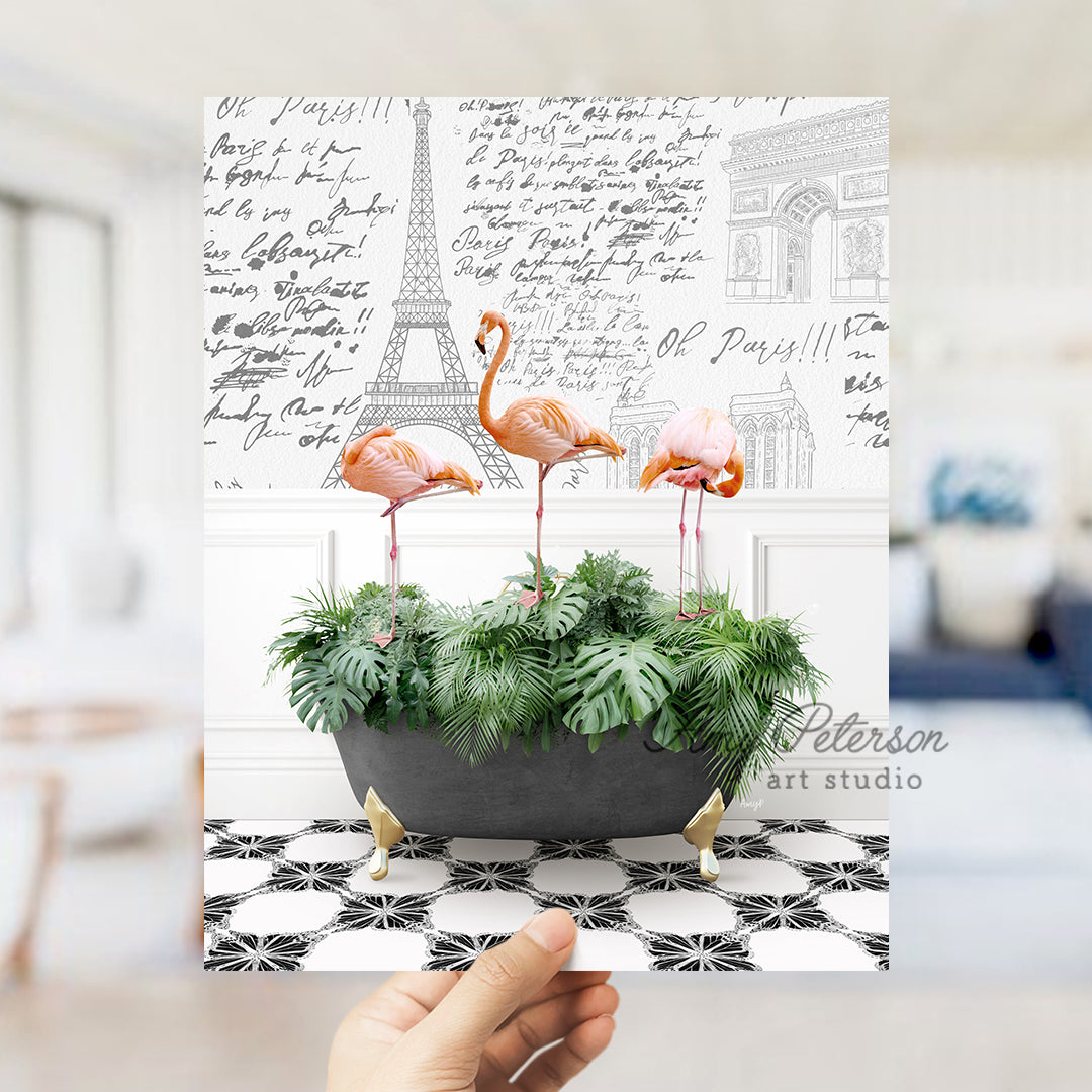 a hand holding a card with three flamingos in a planter