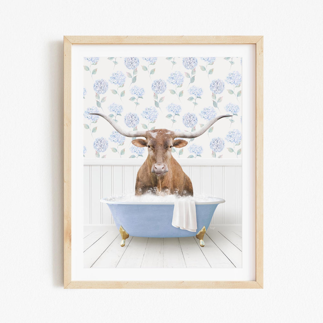 A brown cow with large horns is sitting in a blue bathtub filled with bubbles, surrounded by a floral patterned wall.